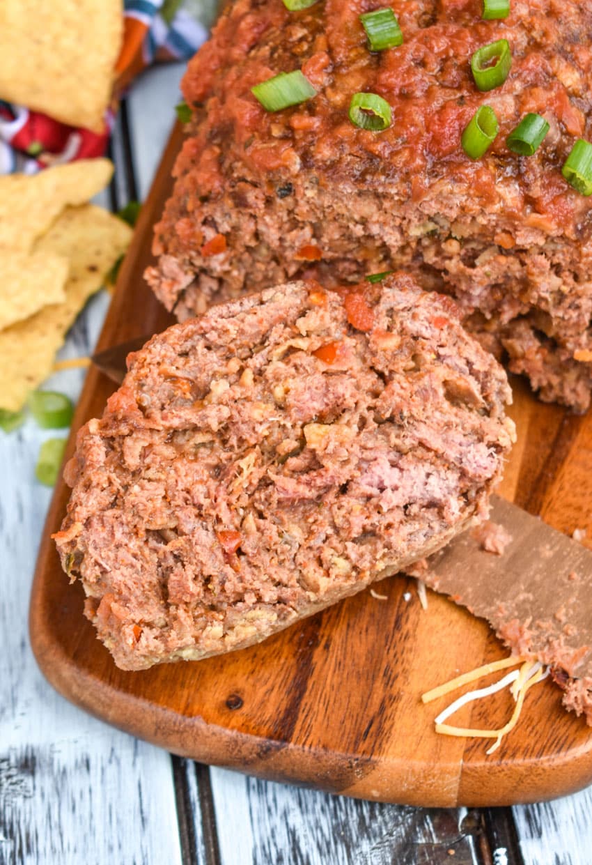 a slice of mexican meatloaf on a wooden cutting board