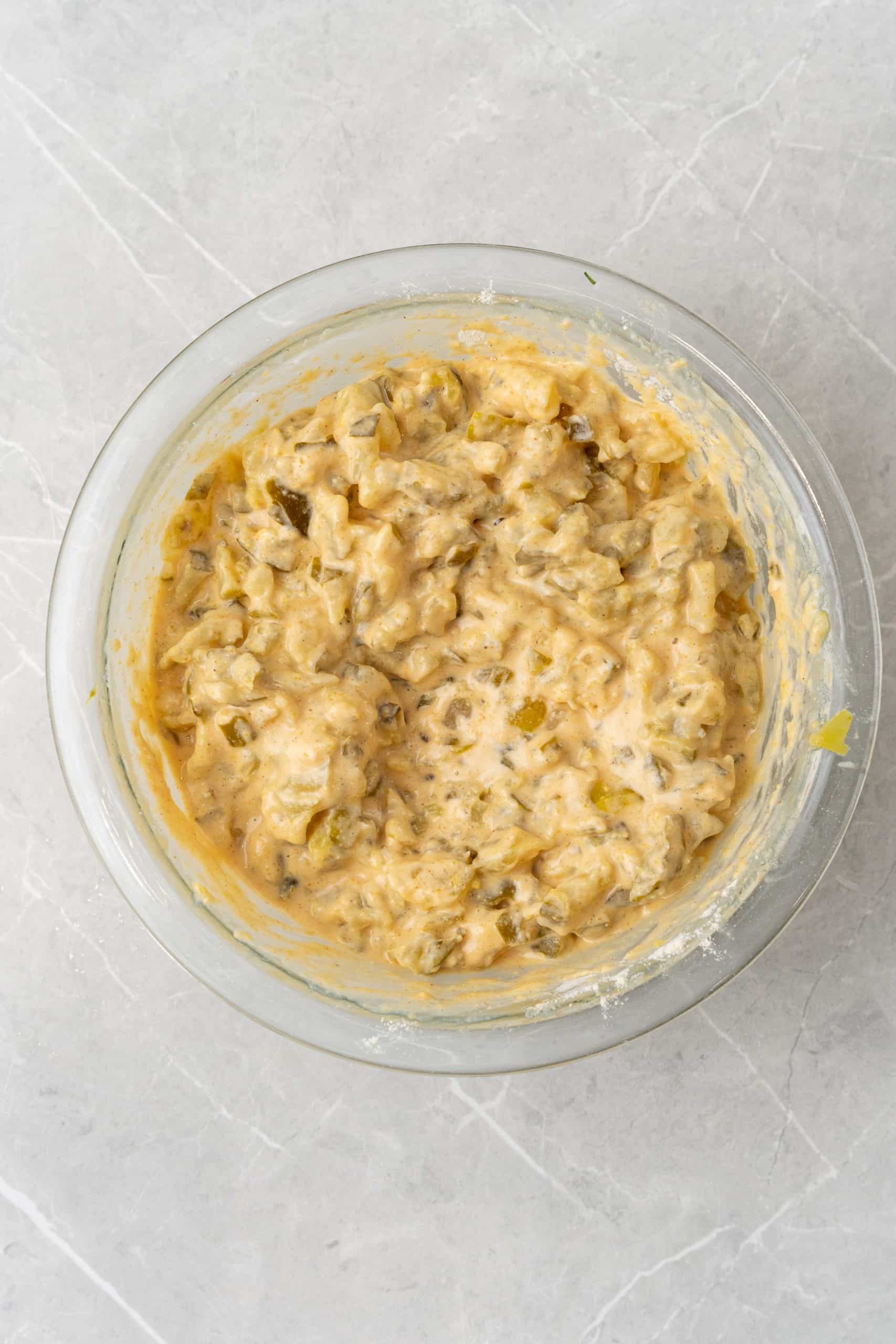 dill pickle fritter batter in a glass mixing bowl