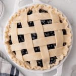 an unbaked blueberry pie on a marble countertop