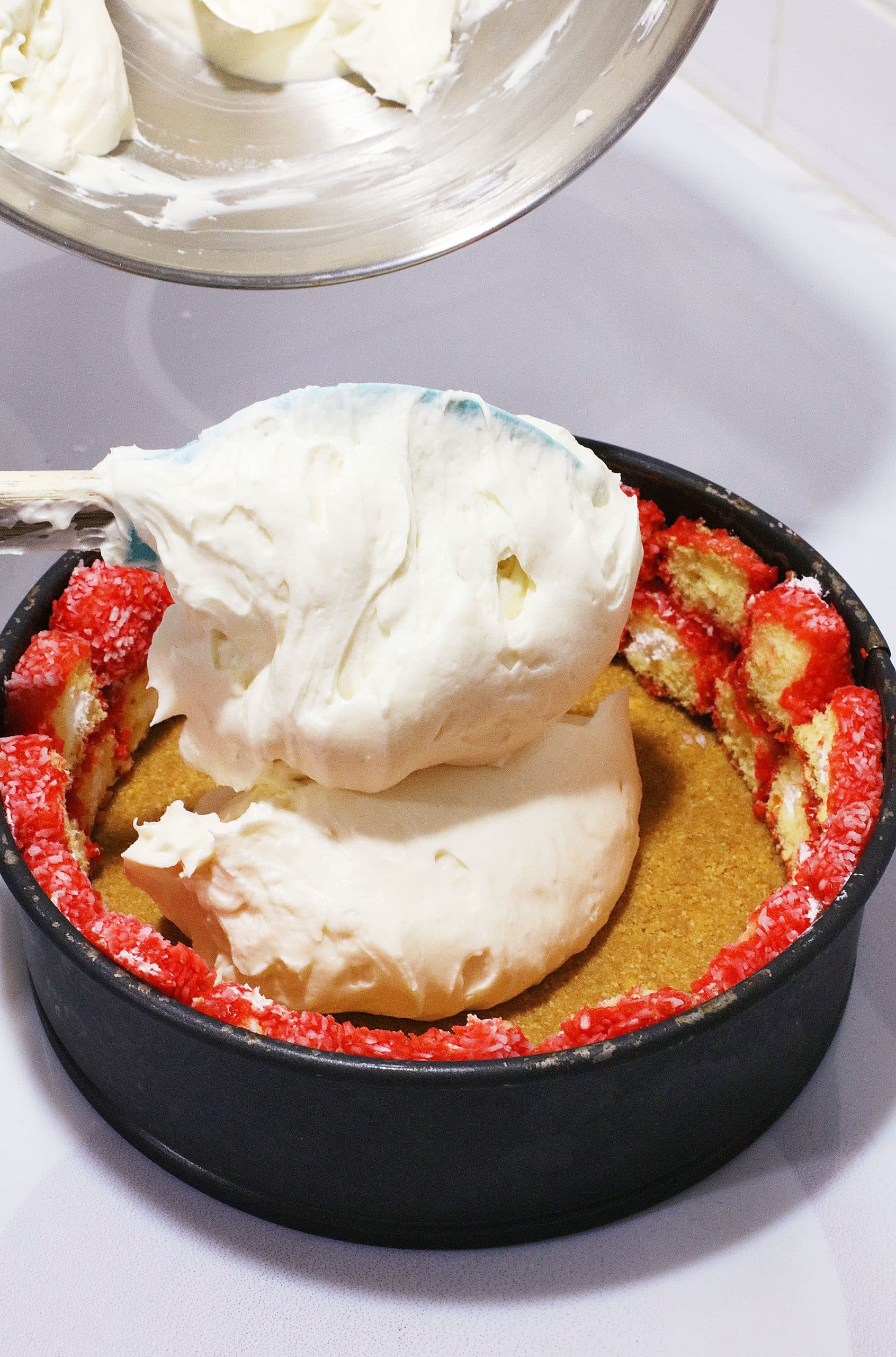 cheesecake filling being spooned into a springform pan