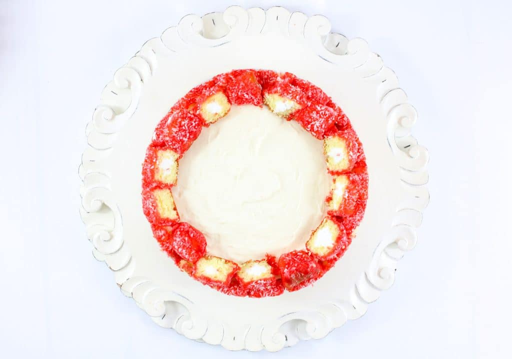 raspberry zinger cheesecake on a white cake stand