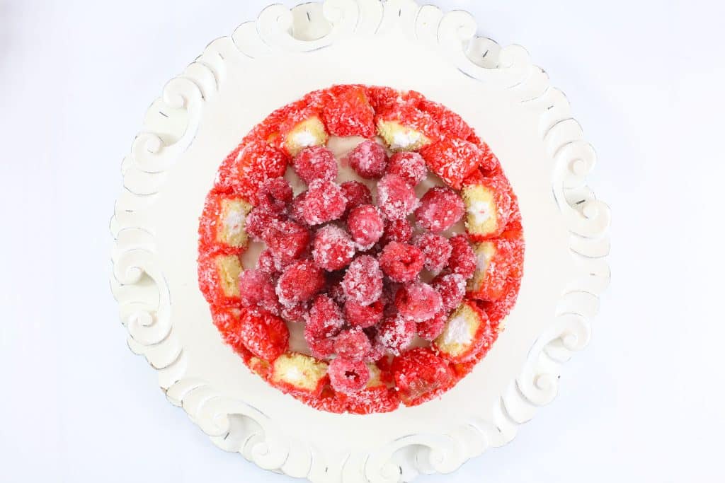 raspberry zinger cheesecake on a white cake stand