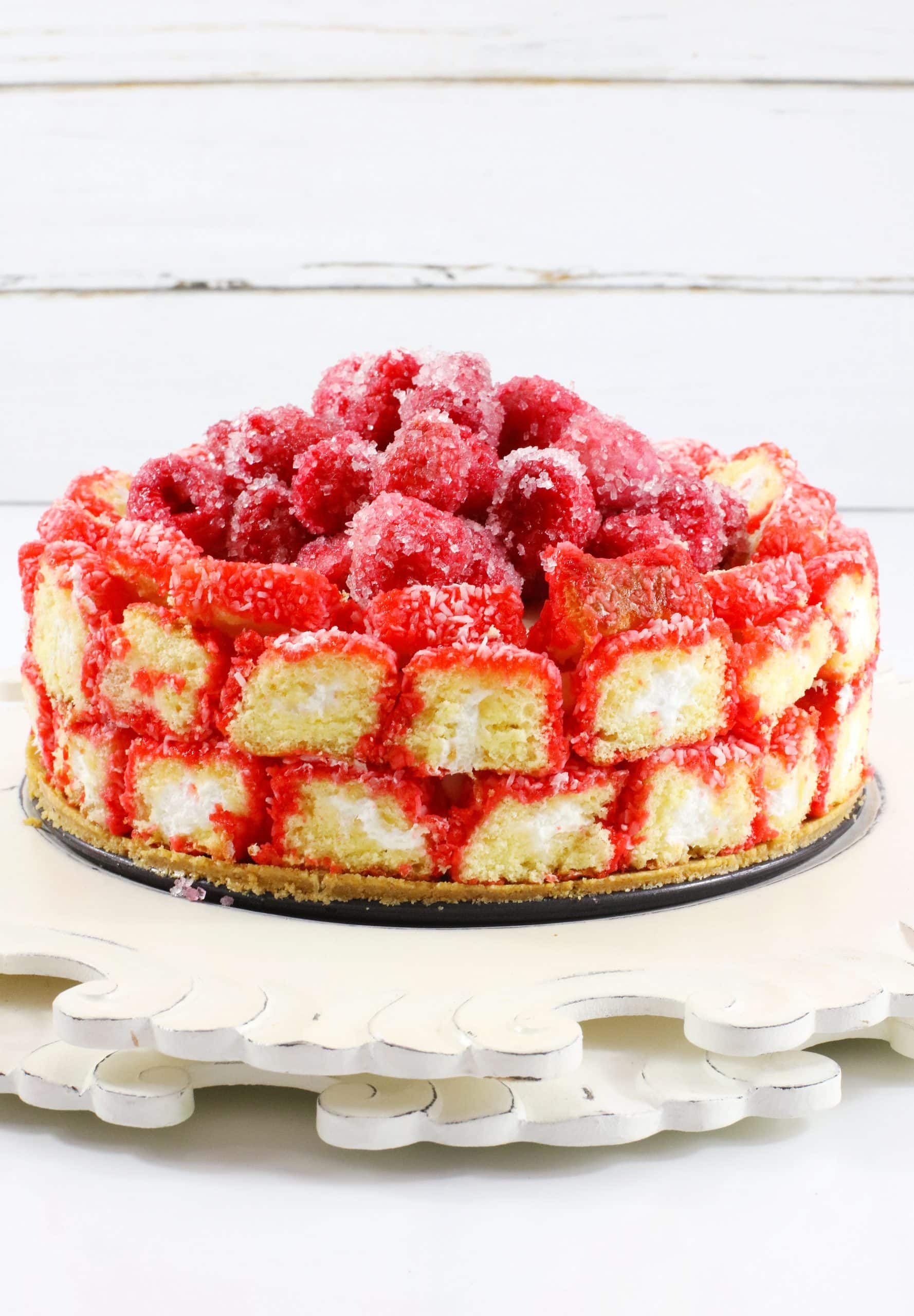 raspberry zinger cheesecake on a white cake stand