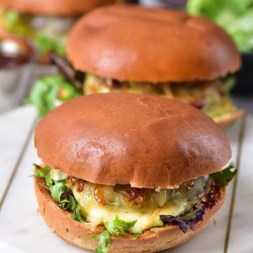two air fryer hamburgers with cheese on a marble cutting board