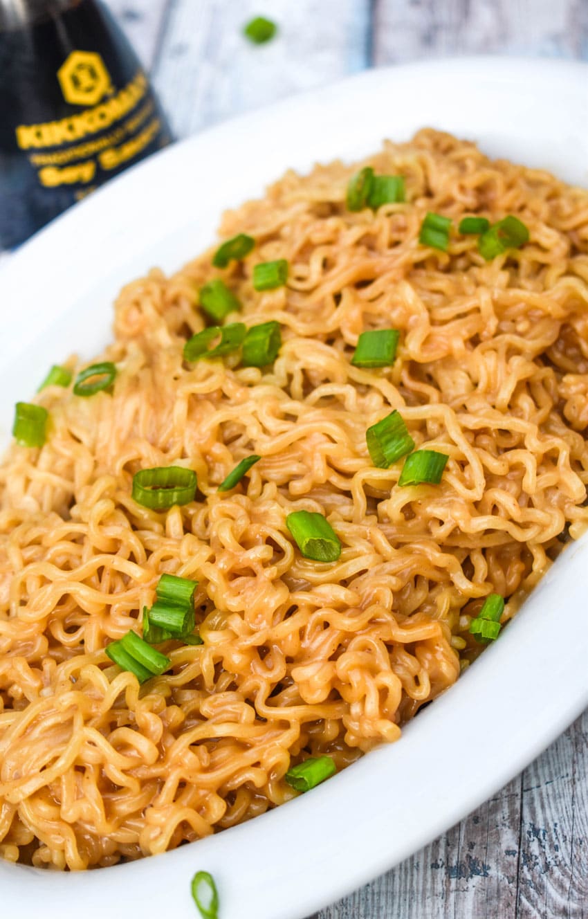 peanut butter ramen in a white serving dish with thinly sliced green onions on top