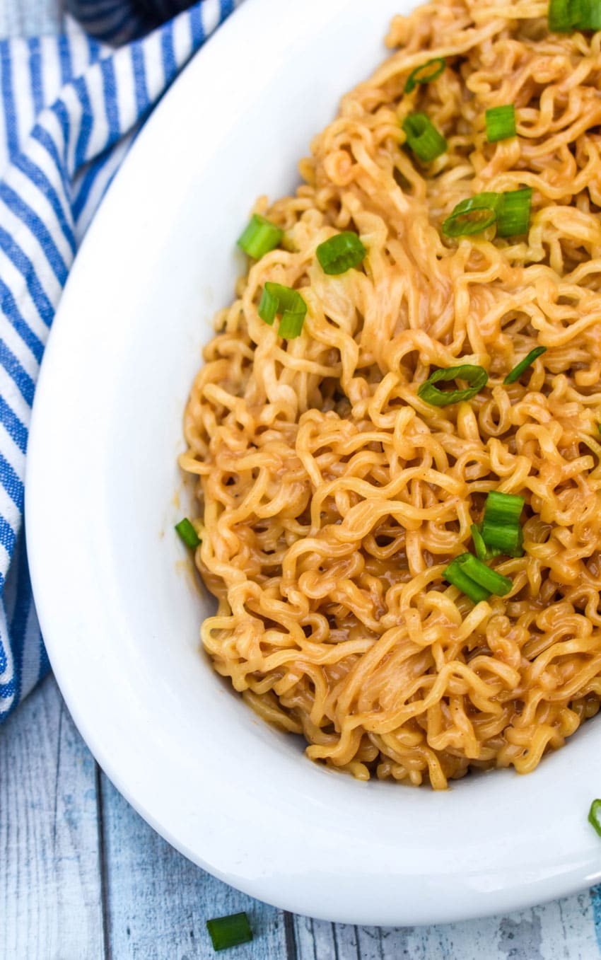 peanut butter ramen in a white serving dish with thinly sliced green onions on top