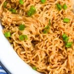 peanut butter ramen in a white serving dish with thinly sliced green onions on top