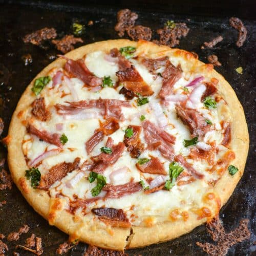 an american pulled pork pizza on a metal baking sheet