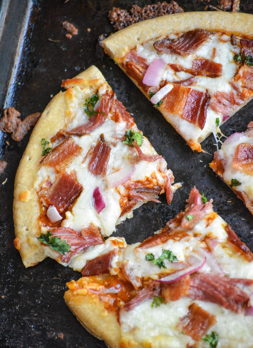 a pulled pork barbecue pizza cut into four quarters