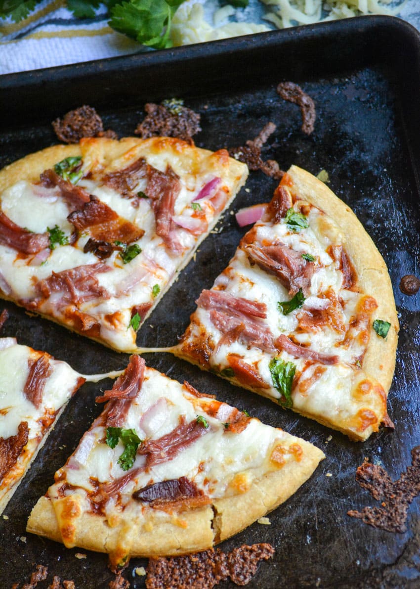a pulled pork barbecue pizza cut into four quarters