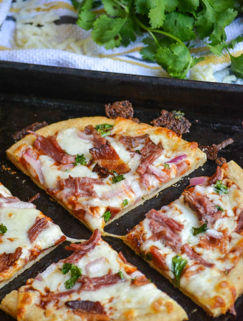 a pulled pork barbecue pizza cut into four quarters