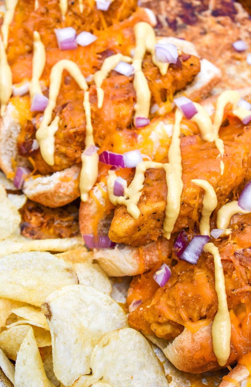 a close up of southern bird dog sandwiches arranged in a row on a metal sheet pan