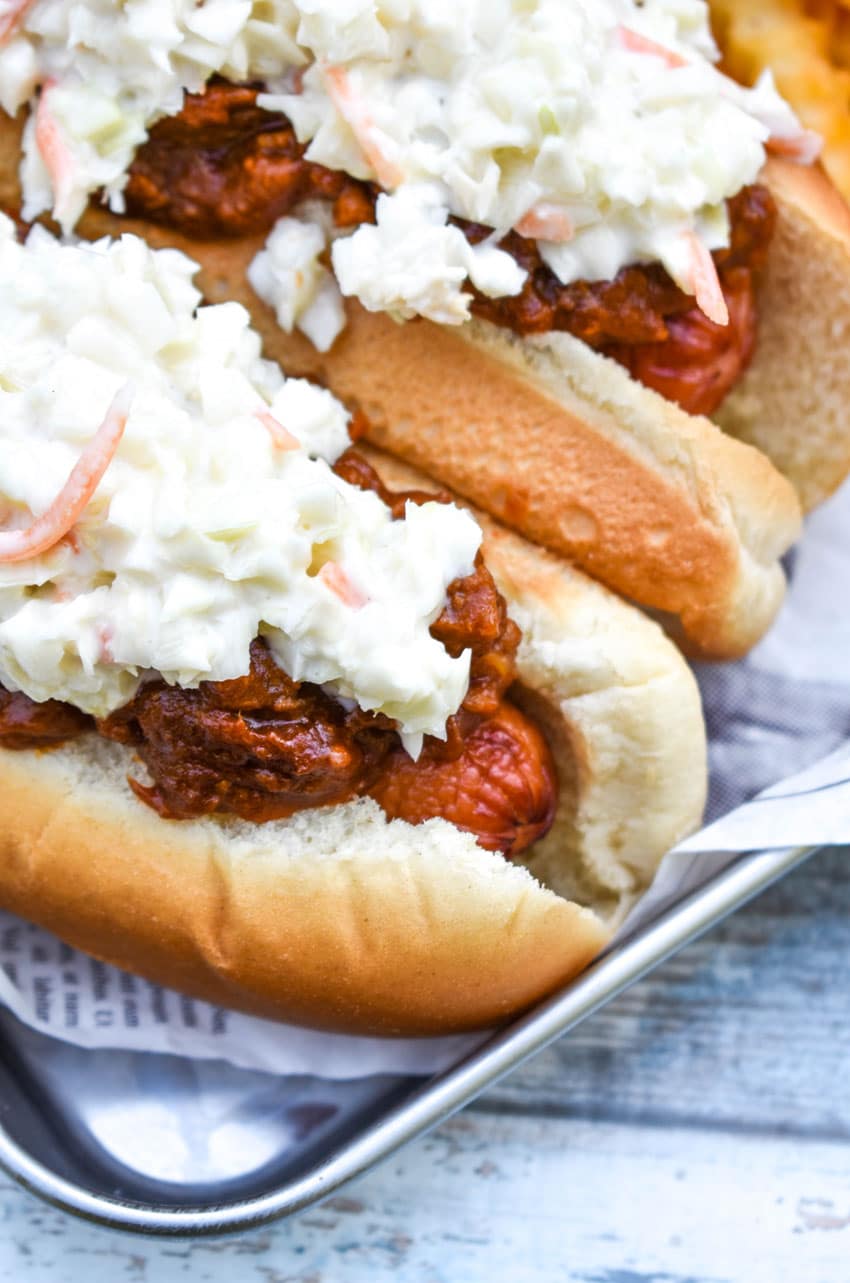 two carolina slaw dogs on a news paper lined metal serving tray