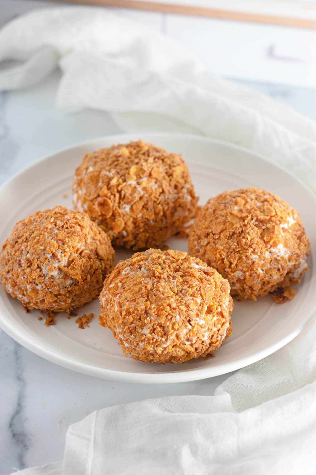 four fried ice cream balls sitting on a small white plate