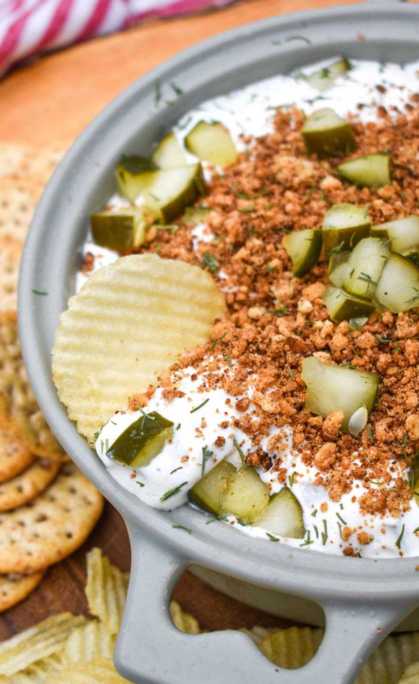 Southern Fried Pickle Dip a chip scooping fried pickle dip out of a gray bowl
