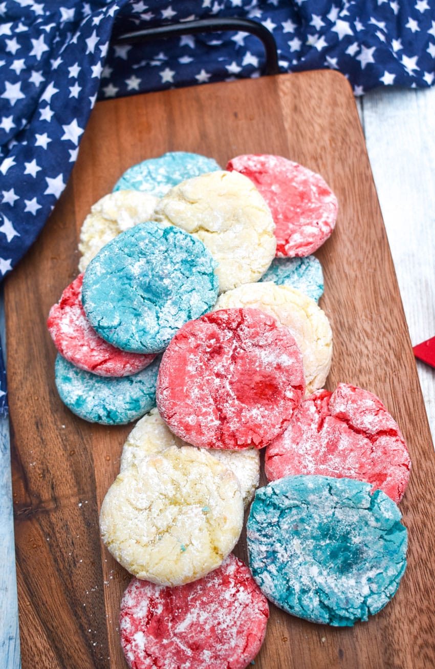red white and blue crinkle cookies on a wooden cutting board