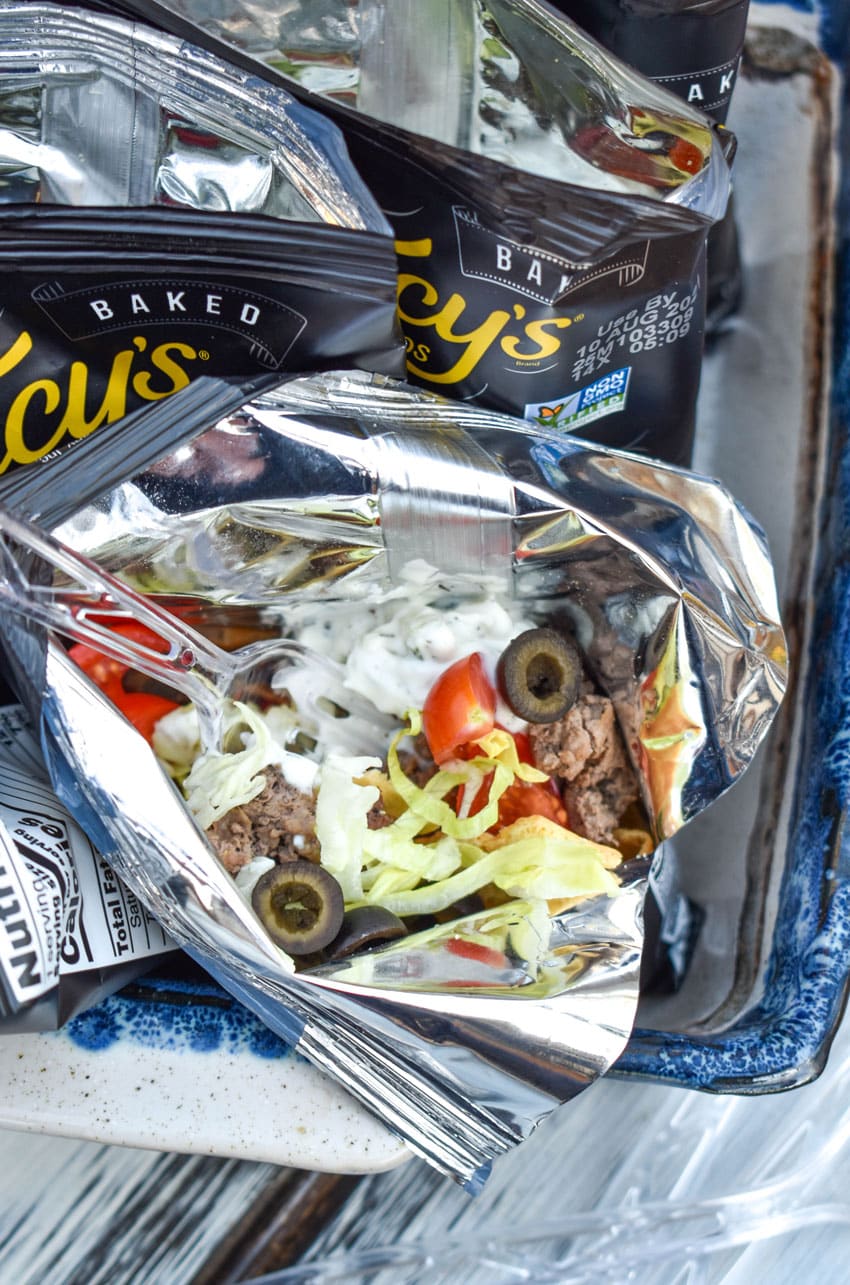 a close up of a walking gyro with a plastic fork stuck in the bag