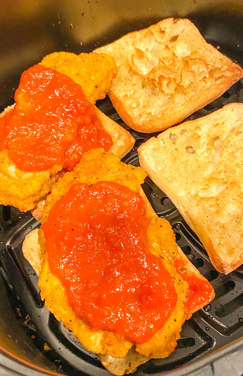 chicken parmesan sandwiches in the basket of an air fryer