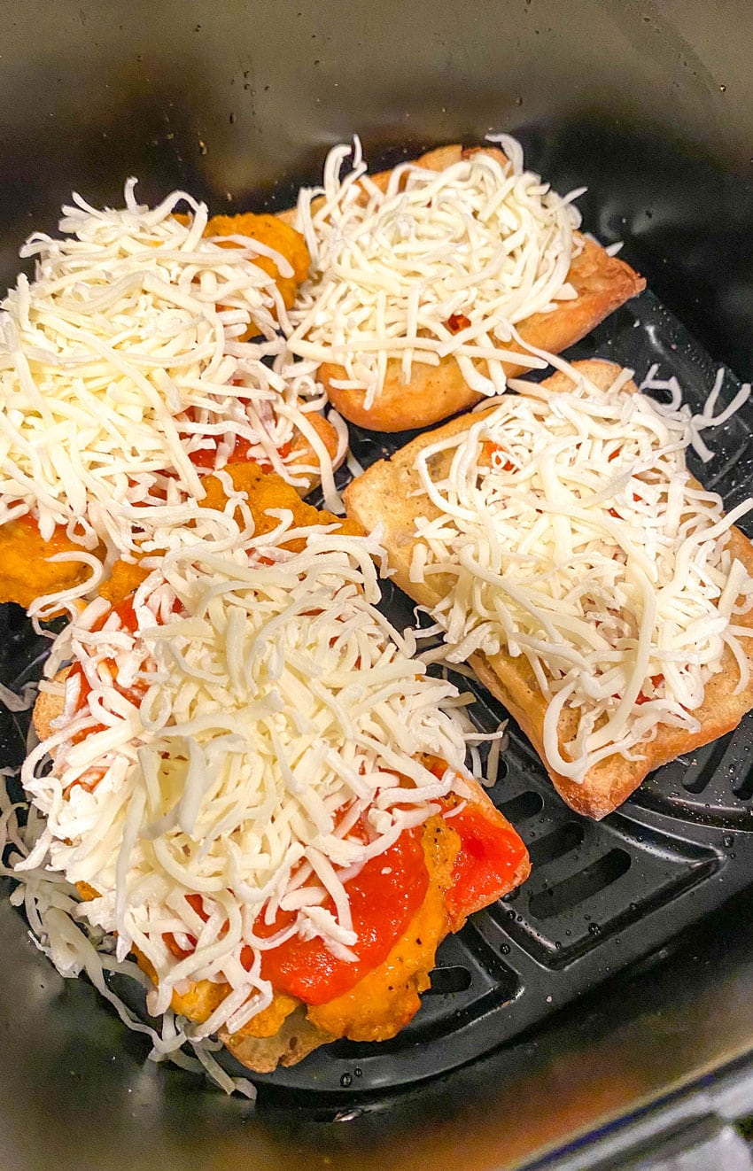 chicken parmesan sandwiches in the basket of an air fryer