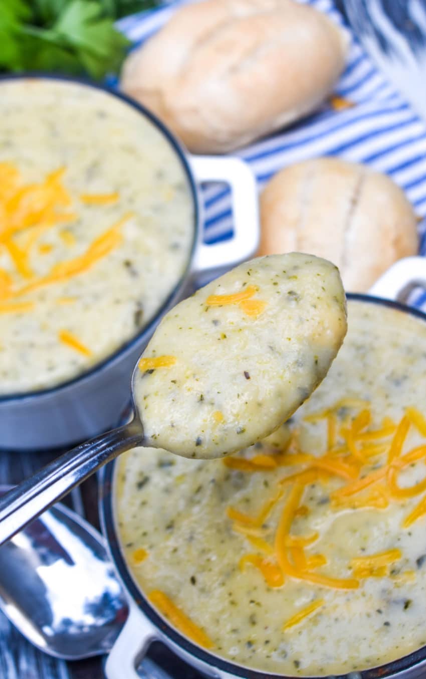 a silver spoon holding up a scoop of easy creamy zucchini soup