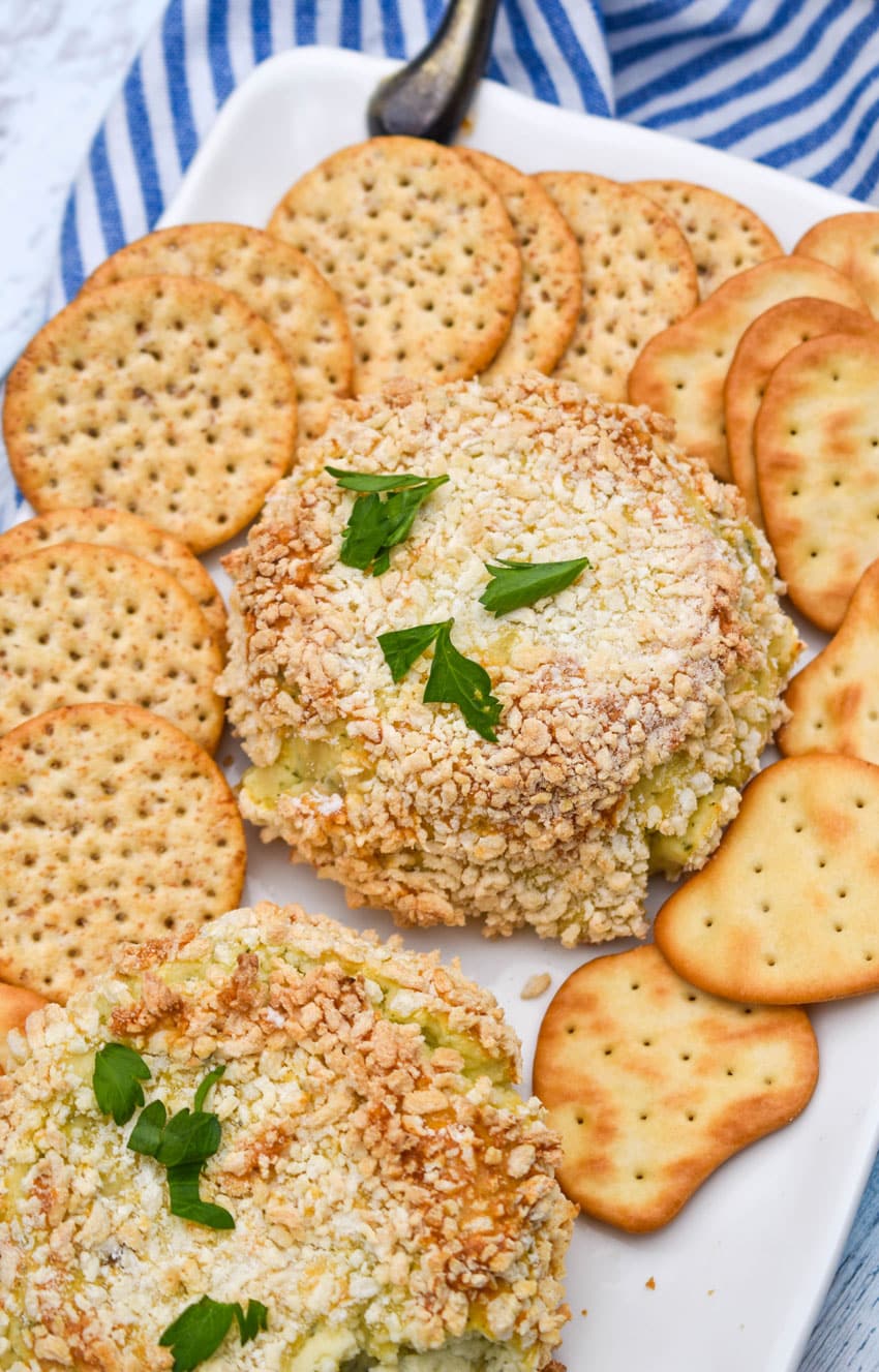crispy baked boursin cheese on a white platter surrounded by different kinds of crackers