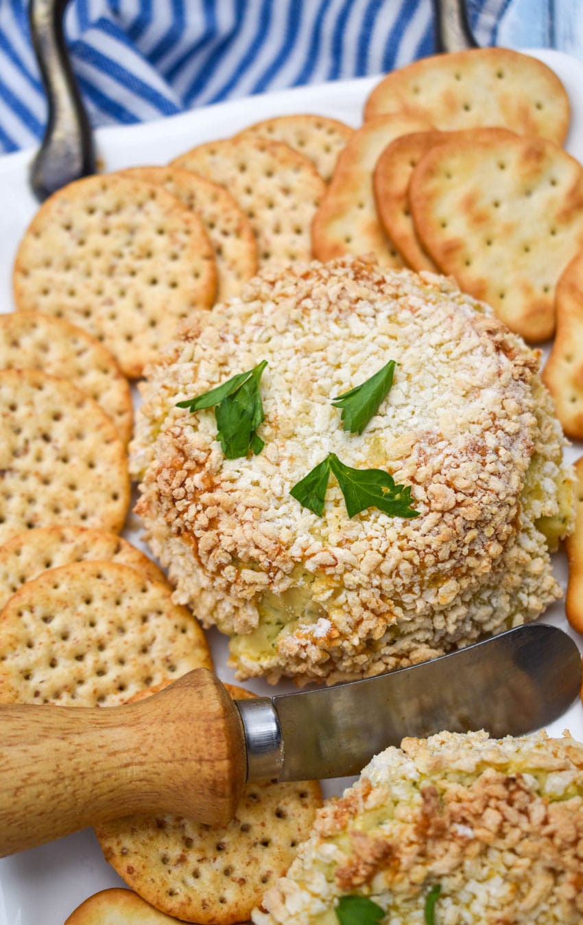 crispy baked boursin cheese on a white platter surrounded by different kinds of crackers