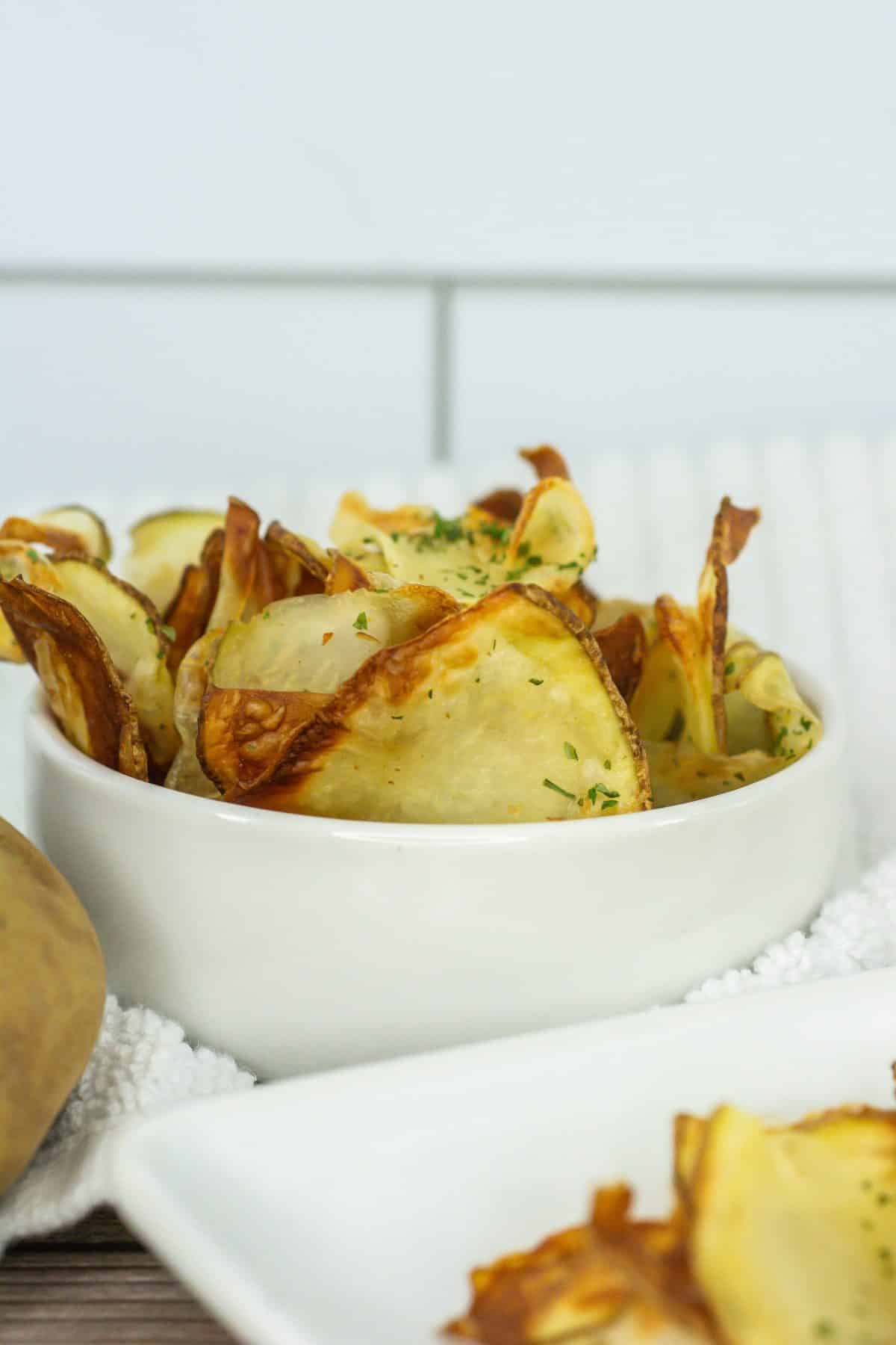 homemade potato chips in a small white bowl