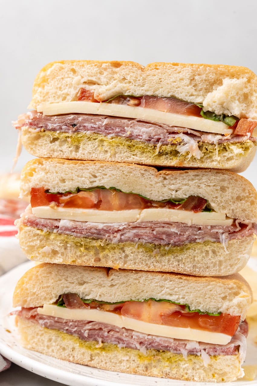 three italian pressed picnic sandwiches stacked on top of each other
