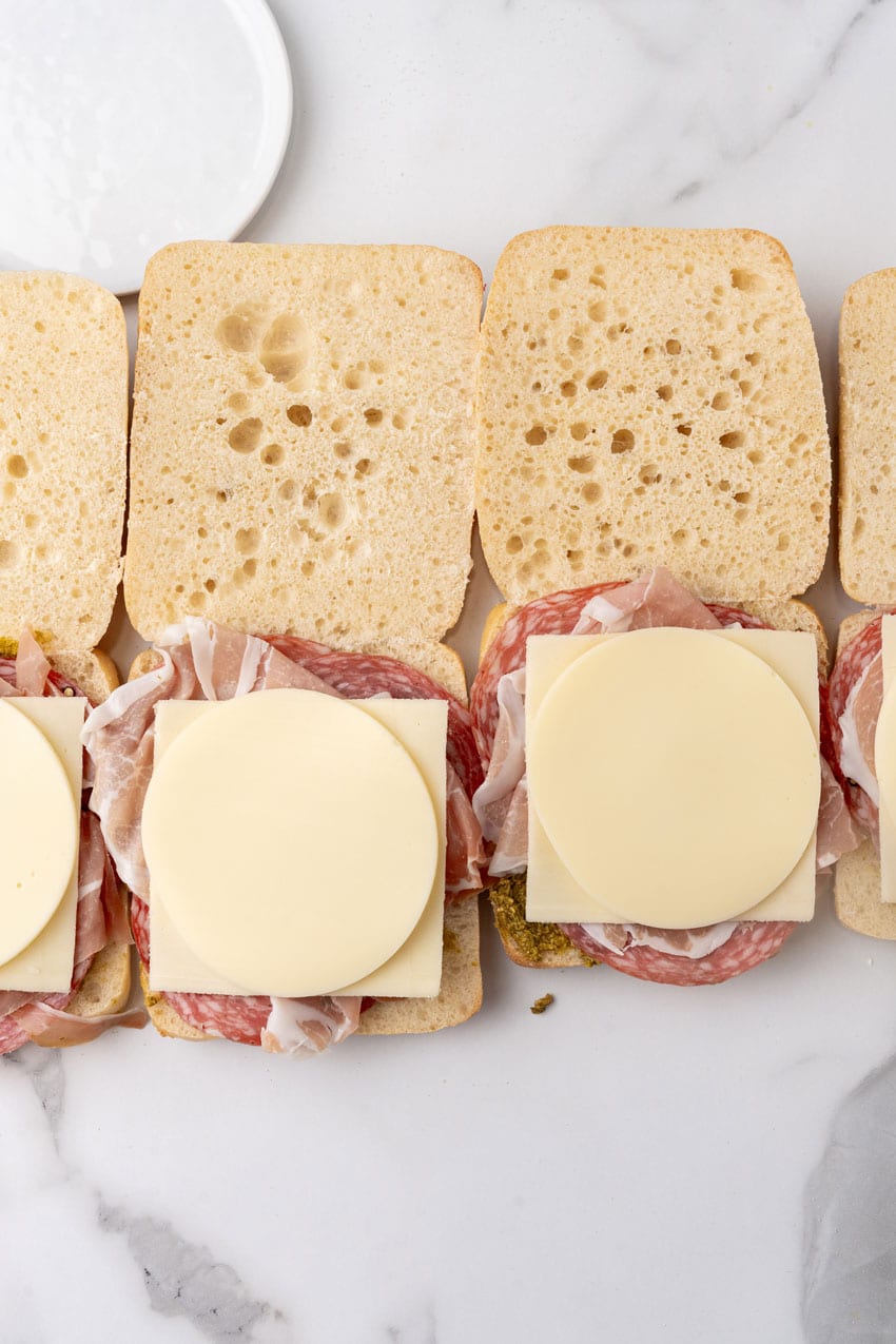 meats and cheeses on sliced ciabatta rolls