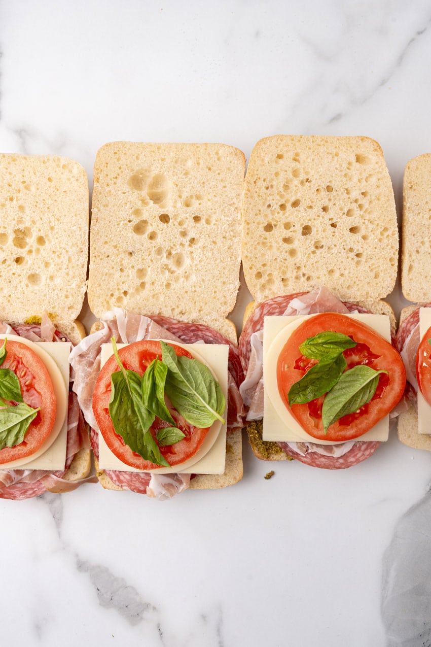 italian meats, cheeses, and vegetables on open face ciabatta rolls