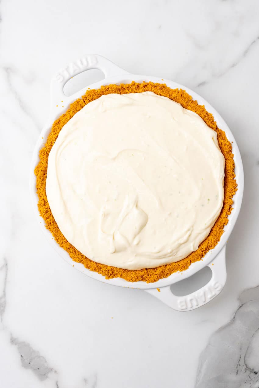 key lime cheesecake filling in a graham cracker crust in a white pie plate