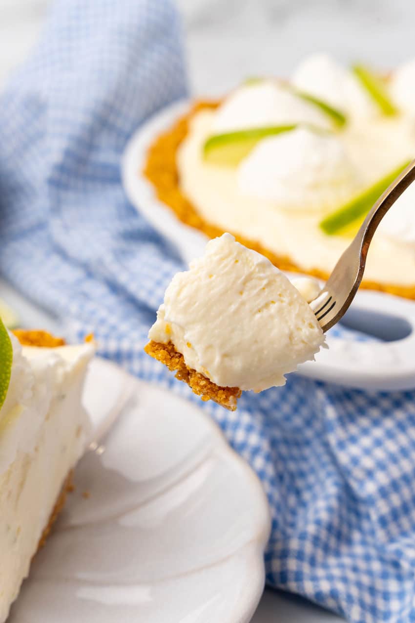 a gold fork holding up a scoop of no bake key lime pie cheesecake