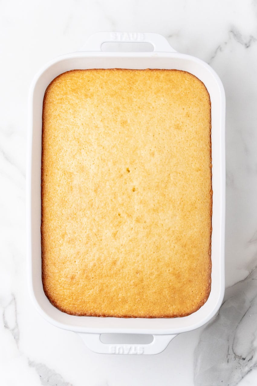 a baked yellow cake in a white baking dish