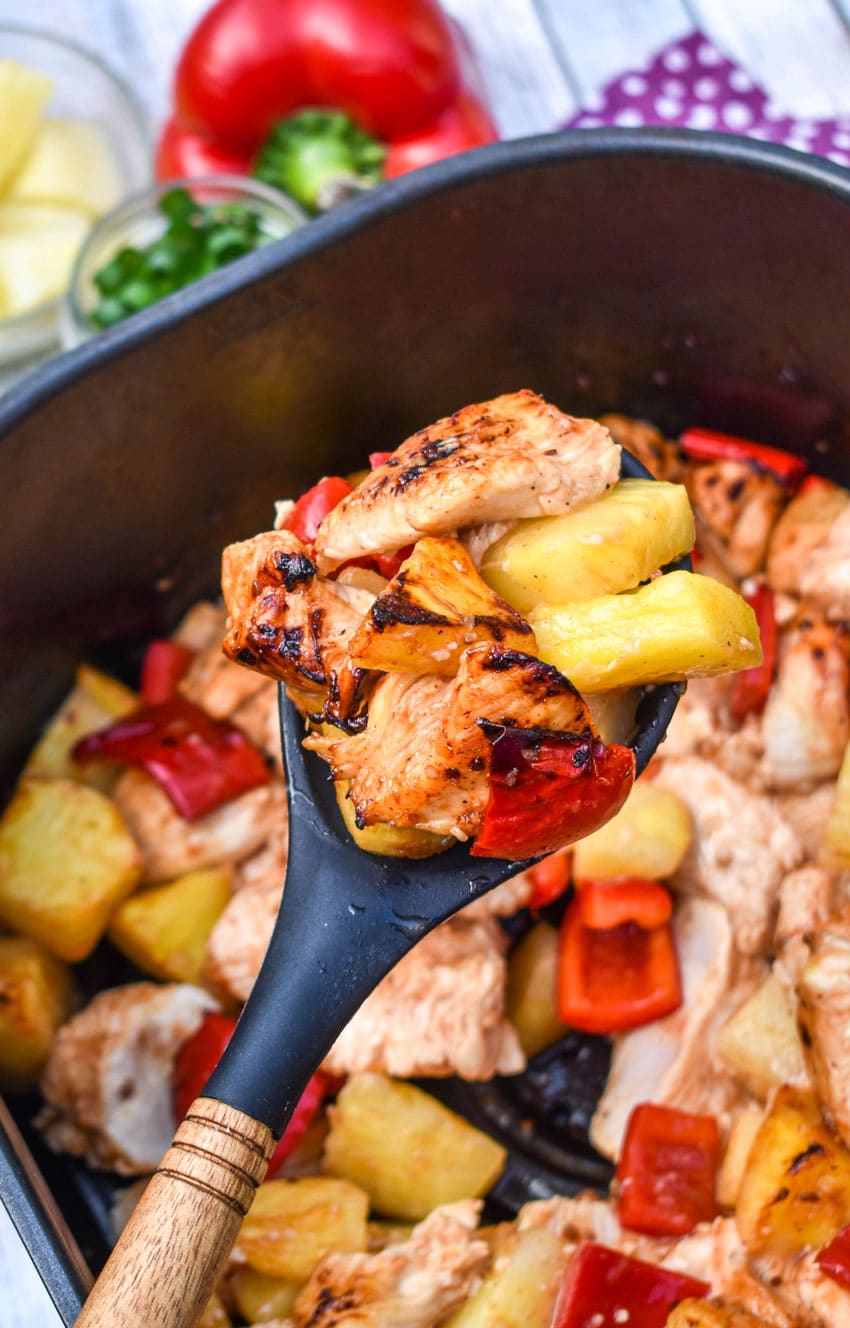 a spoon holding up a scoop of air fryer pineapple chicken
