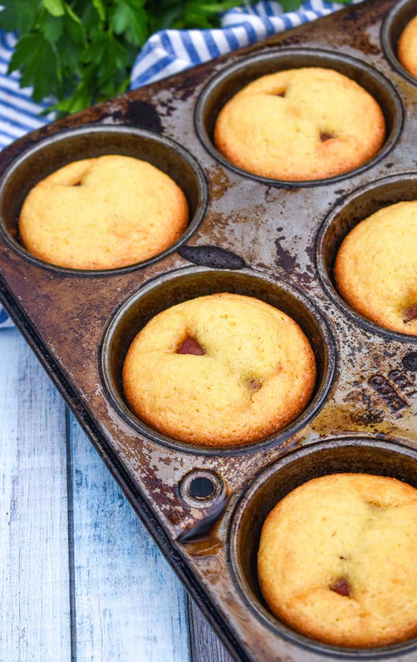 baked corn dog muffins in a metal muffin tin