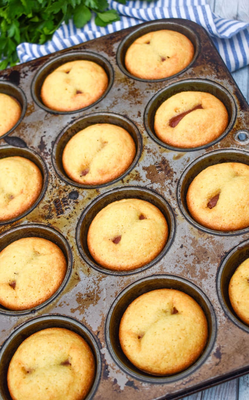 baked corn dog muffins in a metal muffin tin