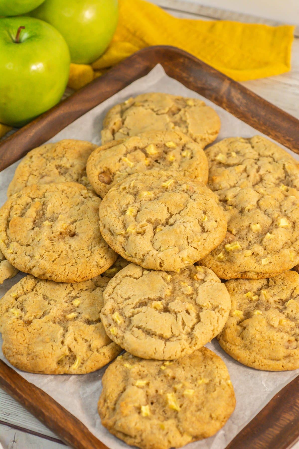 Caramel Apple Cookies caramel apple cookies stacked on a parchment paper lined baking sheet