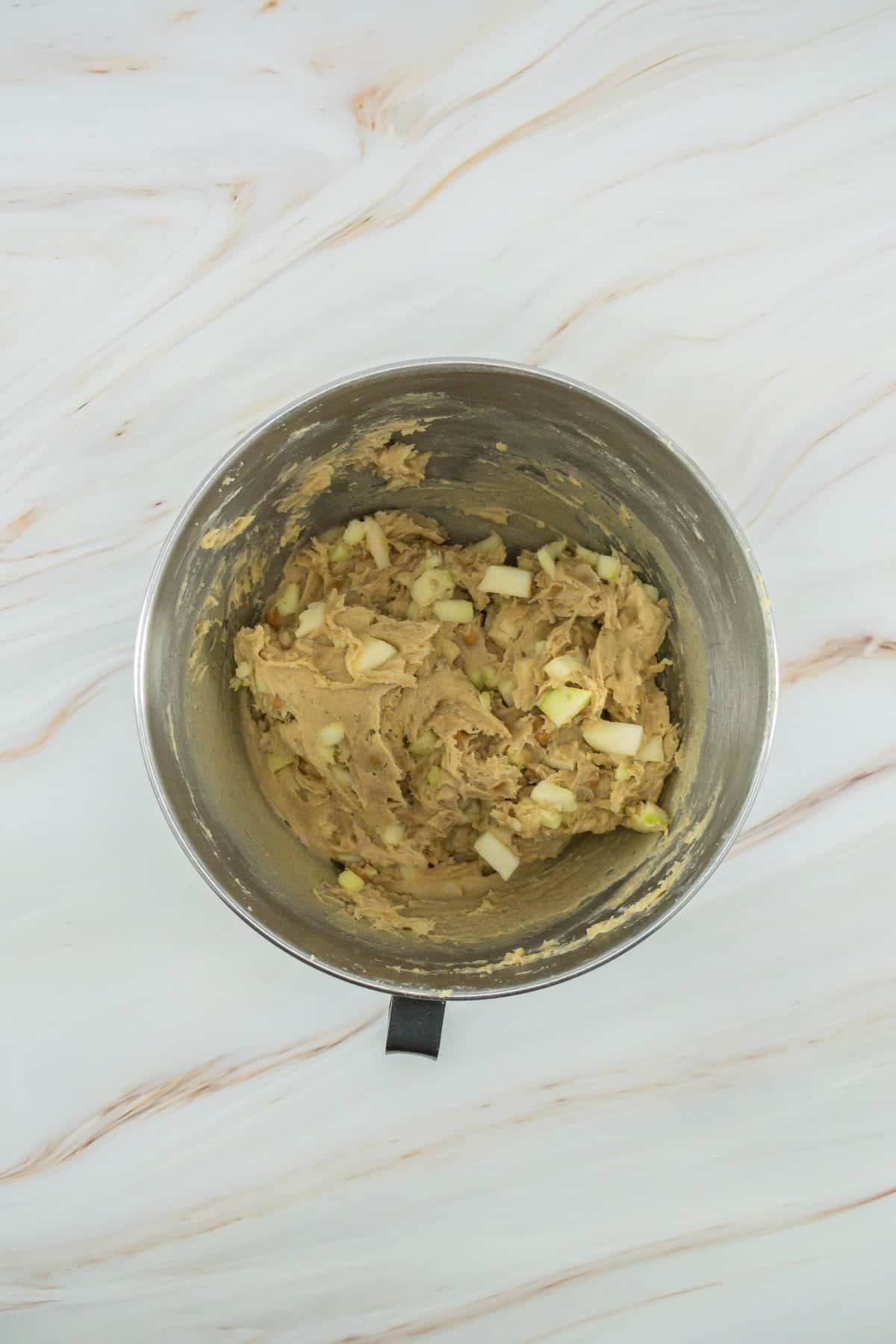 caramel apple cookie batter in a metal mixing bowl
