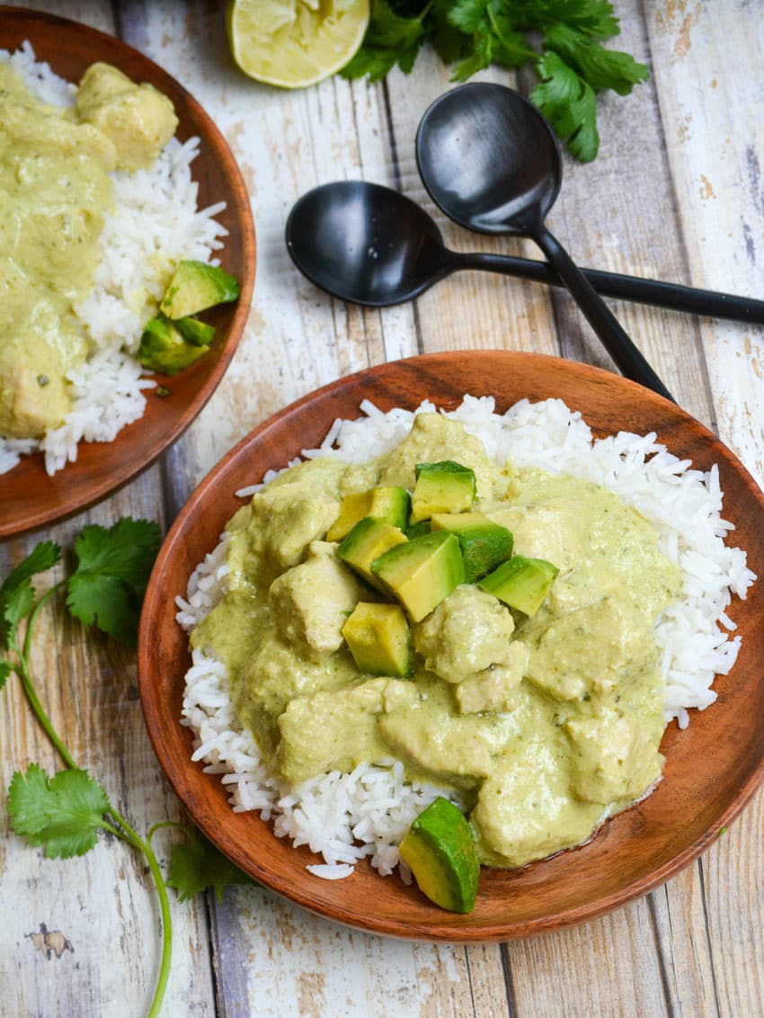 instant pot creamy avocado chicken over steamed white rice on a wooden plate