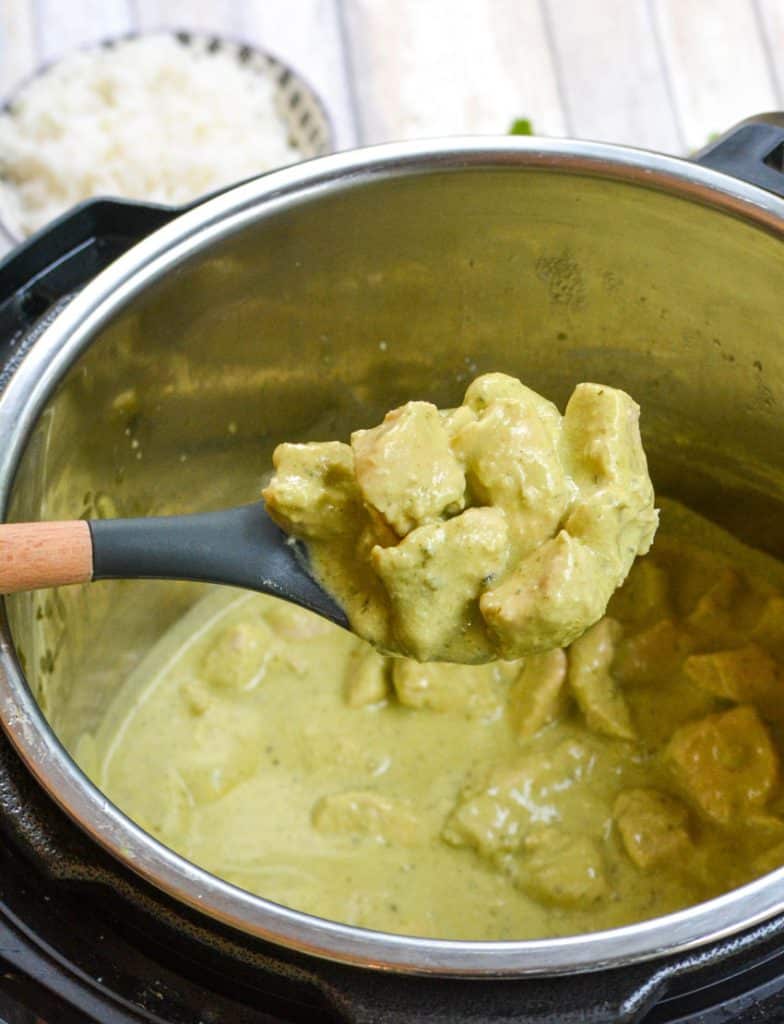 a wooden handled spoon scooping creamy avocado chicken out of an instant pot