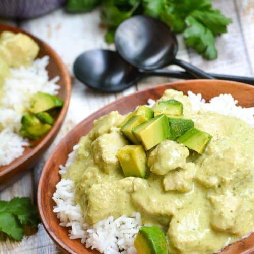 instant pot creamy avocado chicken over steamed white rice on a wooden plate