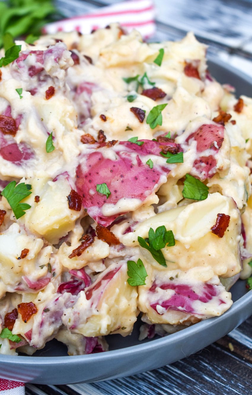 Instant pot bacon ranch potatoes topped with fresh parsley leaves in a large gray bowl