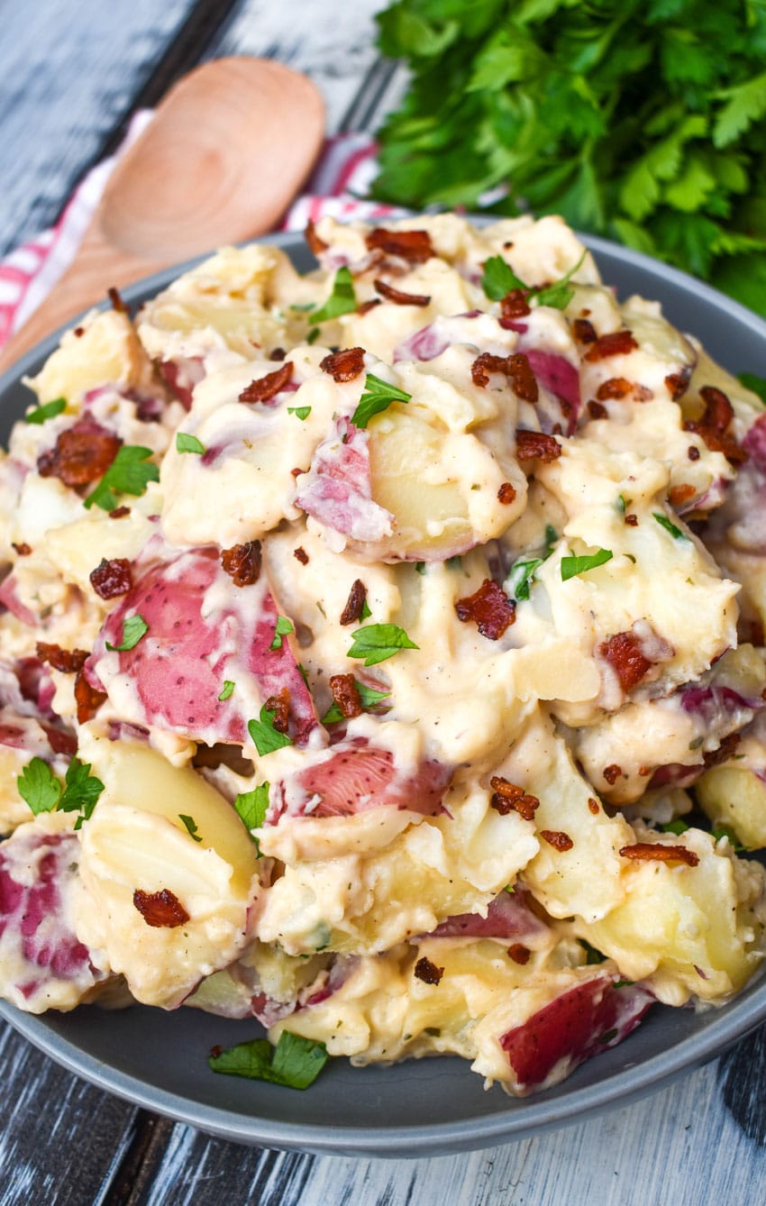 Instant pot bacon ranch potatoes topped with fresh parsley leaves in a large gray bowl