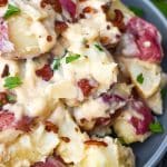 Instant pot bacon ranch potatoes topped with fresh parsley leaves in a large gray bowl