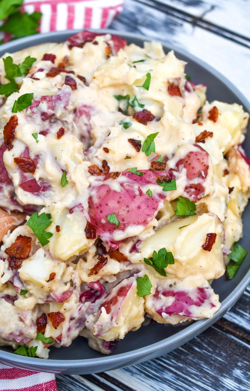 Instant pot bacon ranch potatoes topped with fresh parsley leaves in a large gray bowl