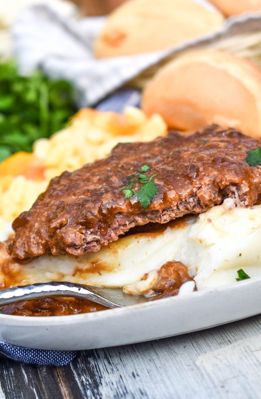 slow cooker cube steak with gravy served over mashed potatoes