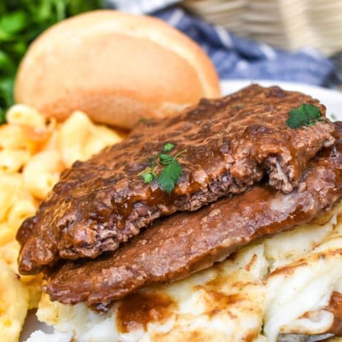 slow cooker cube steak with gravy served over mashed potatoes