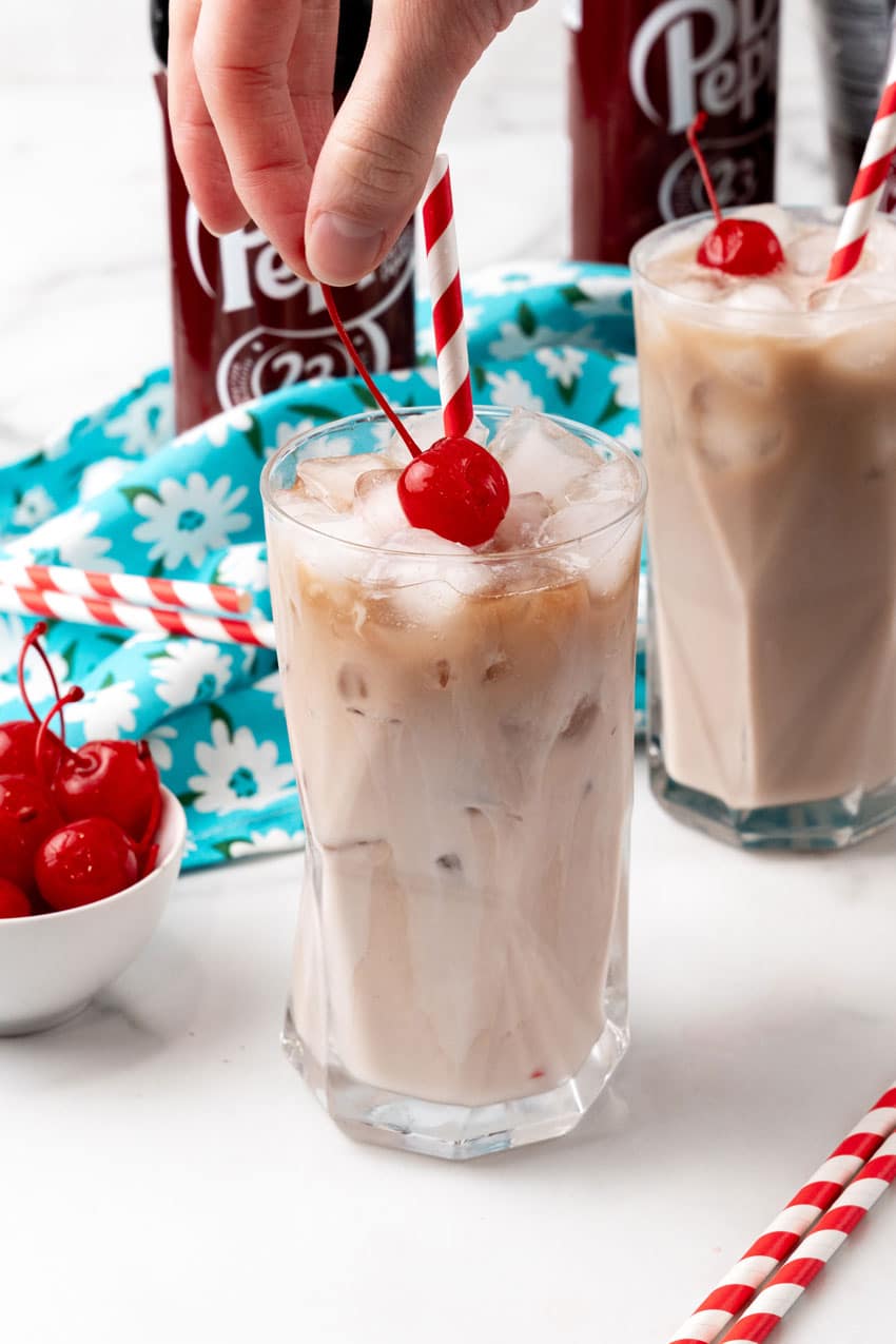 dirty soda recipe in a glass jar with a paper straw