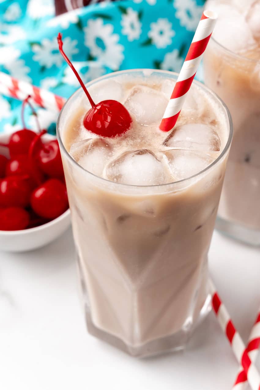 dirty soda recipe in a glass jar with a paper straw