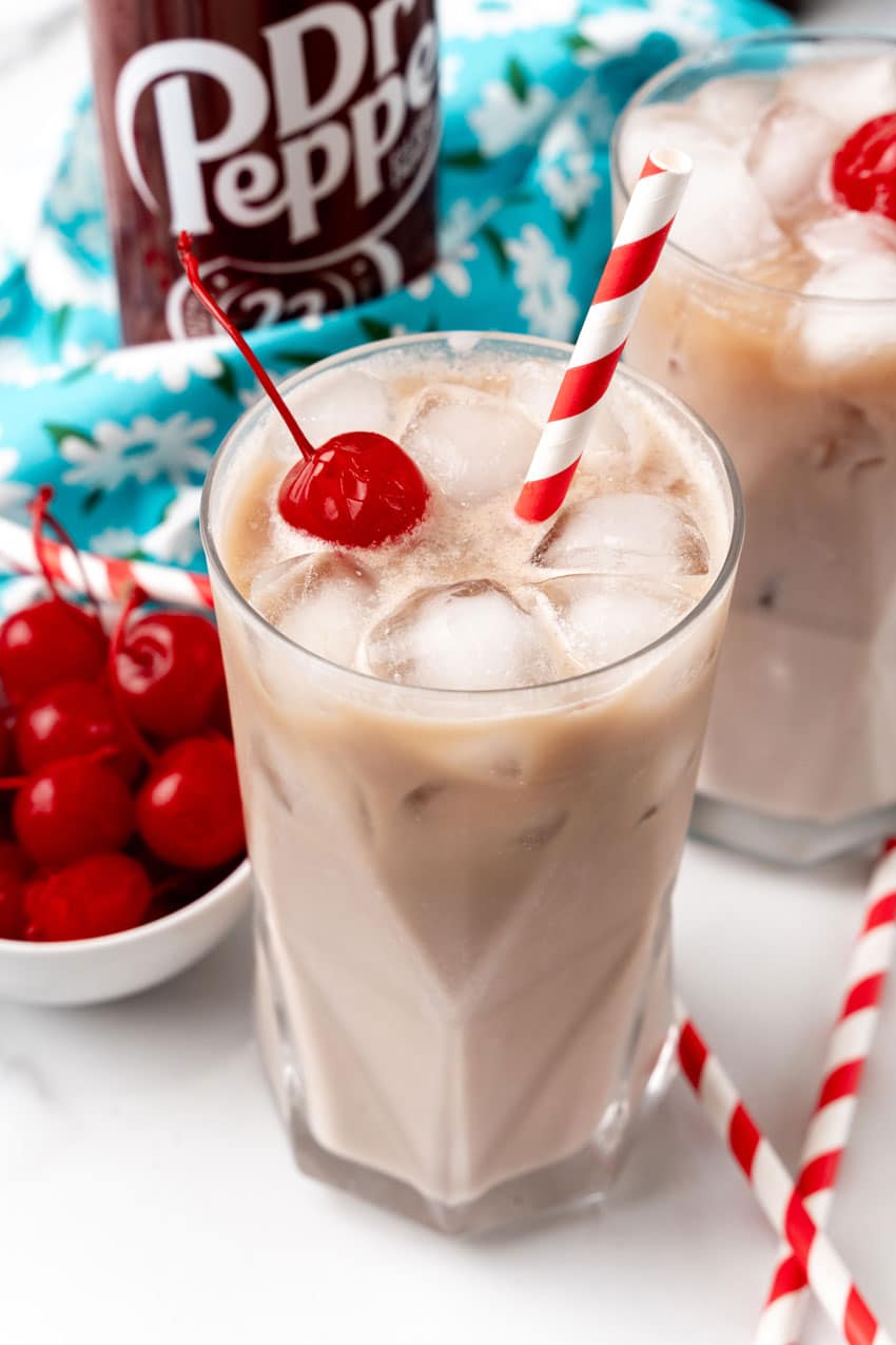 dirty soda recipe in a glass jar with a paper straw